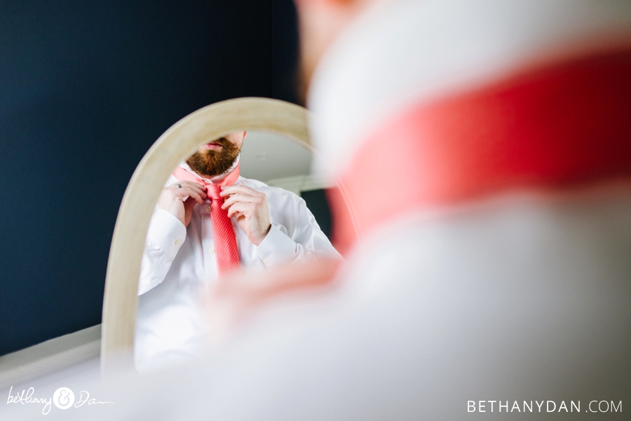 A groomsmen making sure his tie is just right