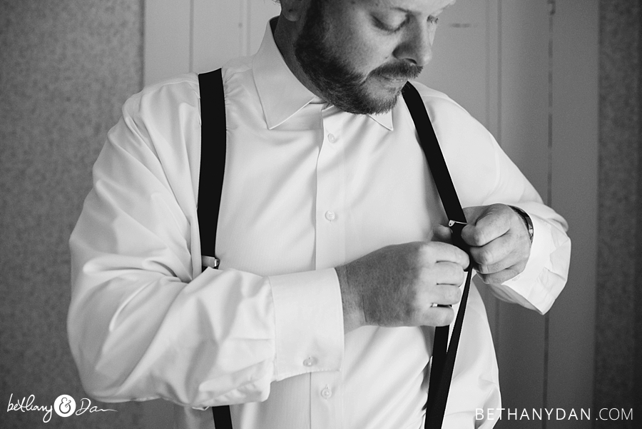 The groom adjusts his suspenders