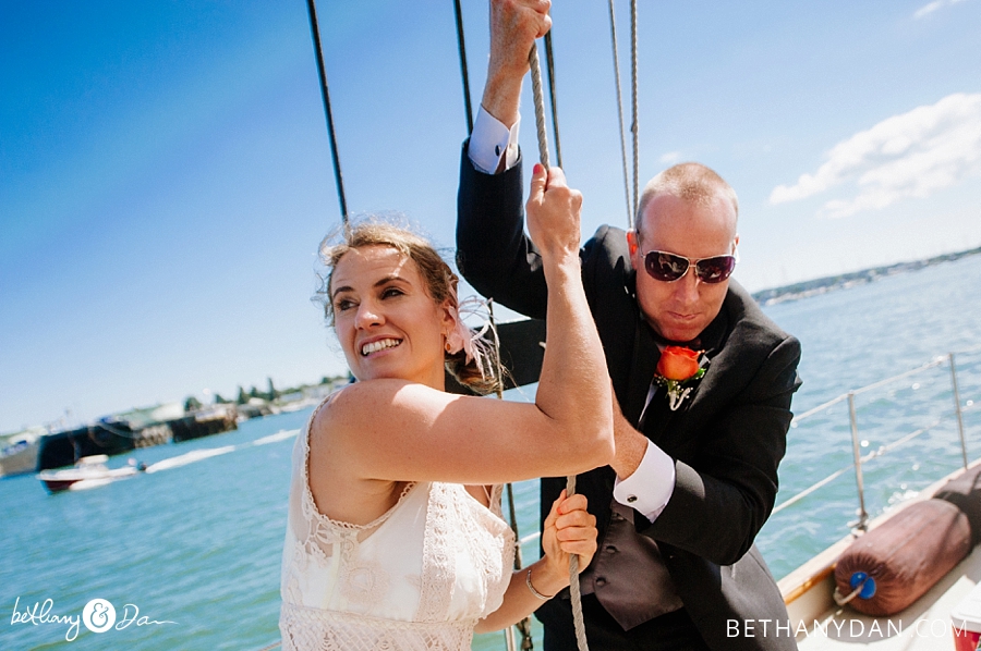 The bride and groom work to hoist the sails